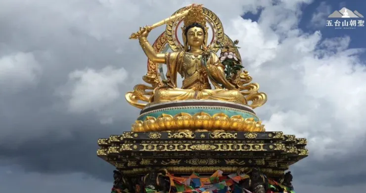 五台山的文殊菩薩金色雕像，菩薩端坐於精美的蓮花座上，右手高舉智慧之劍，象徵斬斷無明與煩惱，左手持蓮花，展現清淨與智慧的象徵。