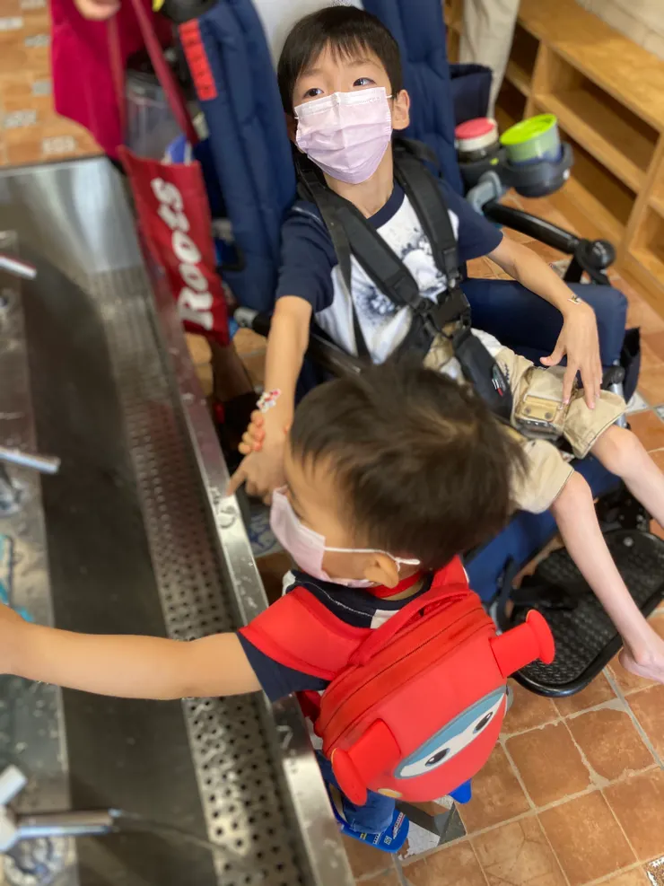 祐懿兄弟用行動證明【融合】是理所當然的日常。~兩歲弟弟牽九歲哥哥的手靠近洗手台要幫他洗手，哥哥手上的貼紙也是弟弟貼的。〔2020〕〕