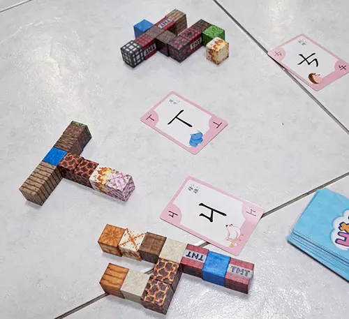 抽卡後，用方形磁鐵積木拼出對應注音符號。其實也可以用輕土、樂高等替代，只要他願意動手做，就是好材料。