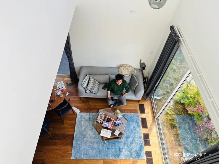 二樓往下拍攝的客廳畫面，挑高的空間很舒適。