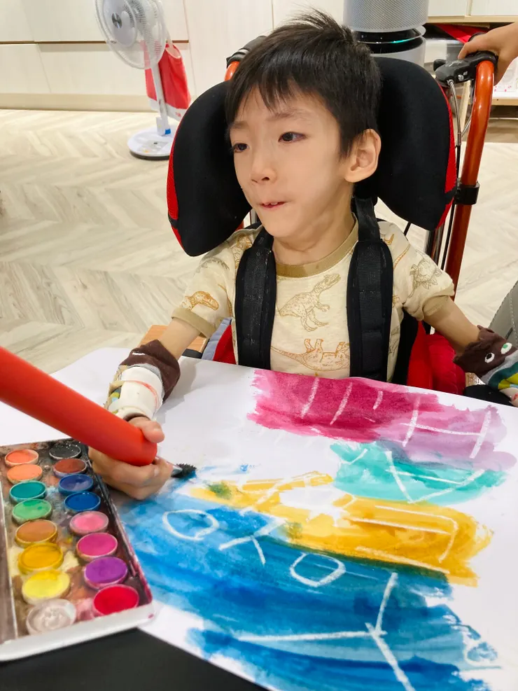 有我們帶著畫畫也可以很幸福。紅色用品是握筆輔具。