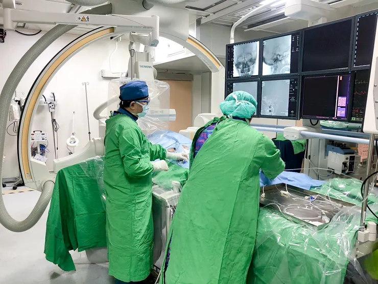 左為神經外科主任羅揚嵐醫師進行動脈內機械取栓手術，羅東博愛醫院腦腦血管介入團隊