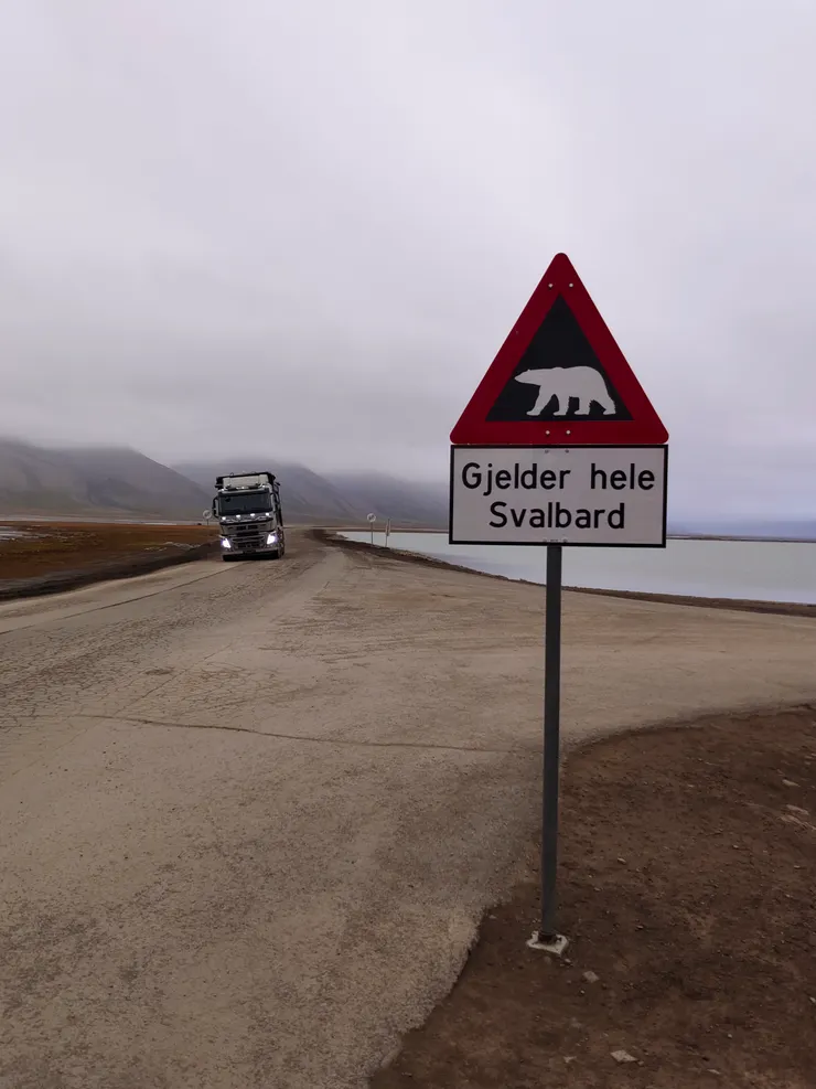 Gjelder hele Svalbard為全斯瓦巴之意，因此，此標誌指全斯瓦巴都得注意北極熊。迎面駛來的是運煤車。