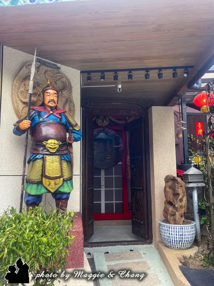 門前威武的將軍雕像、紅燈籠與木雕細節，像是穿越時空來到古代戲劇場景，充滿濃厚傳統文化氣息。