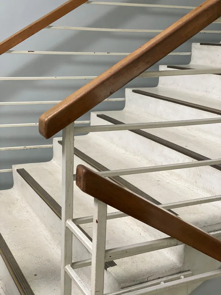 溫潤的木質扶手，搭配鑄鐵欄杆；踏階轉折處呈圓弧型