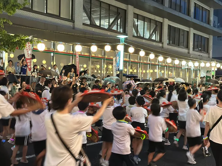 花笠祭遊行時，天上下起了不小的雨，大家都紛紛撐起雨傘，舞者仍然盡力表演