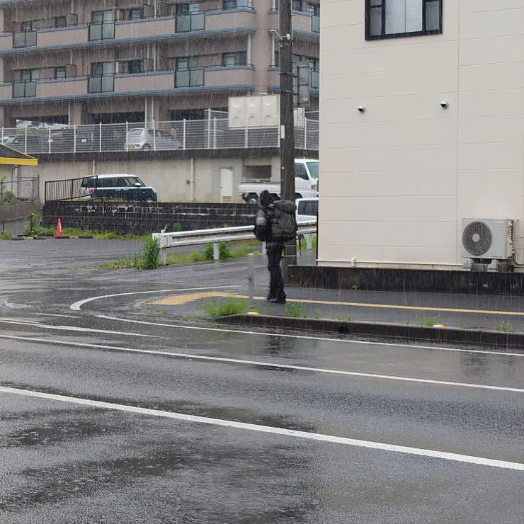隔一條大馬路，與我平行、不撐傘的淋雨旅人。