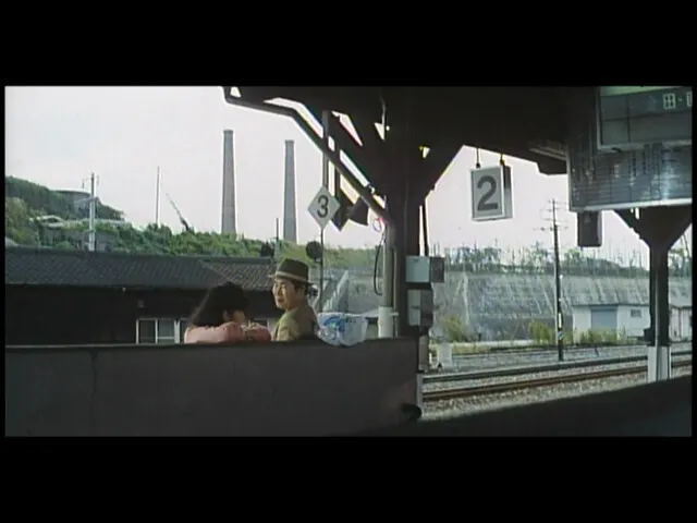 美保在第二月台送別阿寅，背景有兩根大煙囪