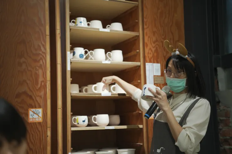 三星四季青花瓷工作人員正向遊客介紹可彩繪的各種器皿。(攝影/曾耀玄)