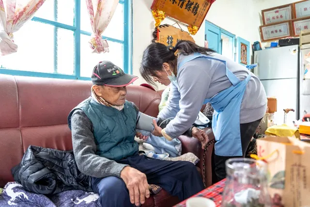 居服員幫爺爺量測血壓，確認數值穩定。