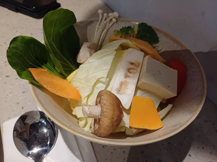 菜盤以蔬菜為主，火鍋料只有蛋餃及魚餃。（有烙印店名的是杏鮑菇）