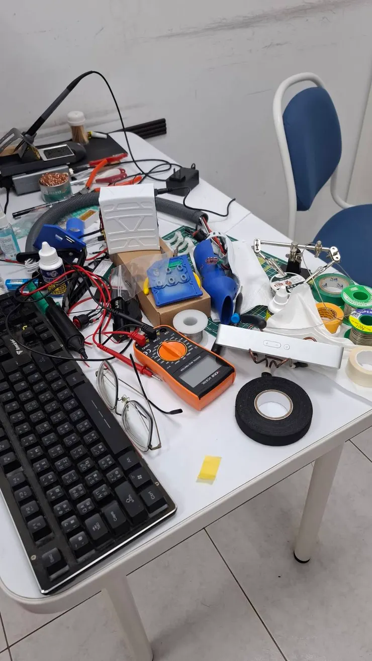 寶哥的戰鬥工作桌現場實錄! 設展前夕的桌面一片混亂,鍵盤、萬用電表、焊接工具、膠帶、電路板、還有媽媽我最害怕亂碰會壞掉的電子零件,全都擠在這張桌上。看似凌亂,其實每樣東西都正為了完成作品而忙碌地「站好崗位」。媽媽我每次經過這張桌子,都有點像是在走進「理工男的思考宇宙」——看不懂,但心疼到不行!