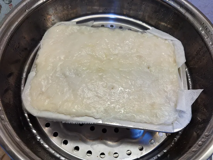 蘿蔔糕蒸好後，掀開烘焙紙，讓水氣散發。