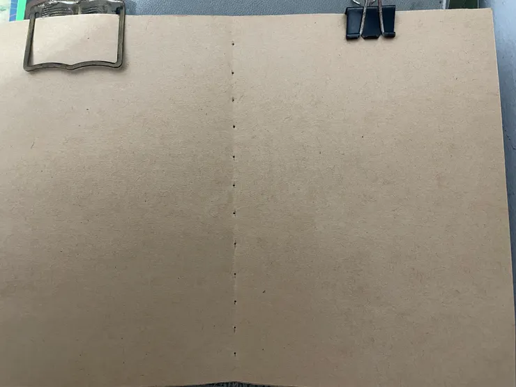 在對折線上刺上一個又一個的小洞洞，洞口是等下要拿來穿針線的。