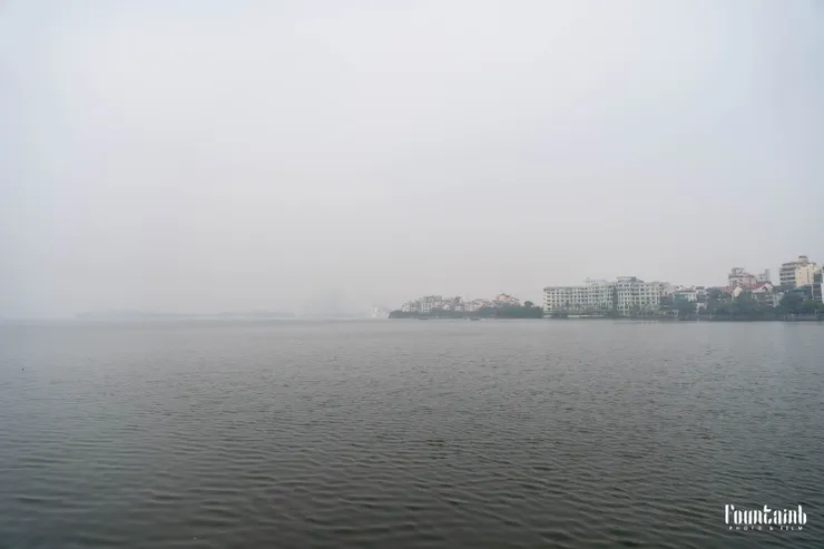 西湖湖景,旁邊有很多人在釣魚。