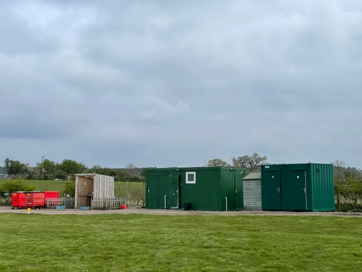 綠色鐵皮屋為盥洗室,旁邊木製搭建的是水槽