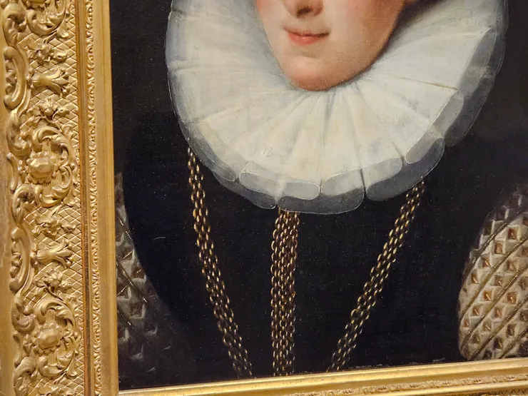 半透明薄紗層層堆疊，項鍊和衣袖上金屬飾物的反光。