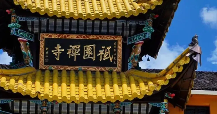 祇園寺的屋頂上，金色的瓦片和雕刻精美的屋脊與藍天相映成趣，匾額上寫著「禪禪國祀」字樣。