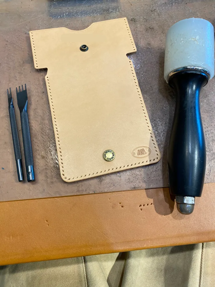 圖8：使用工具在皮革上沿著工匠師已經畫好的線打洞。