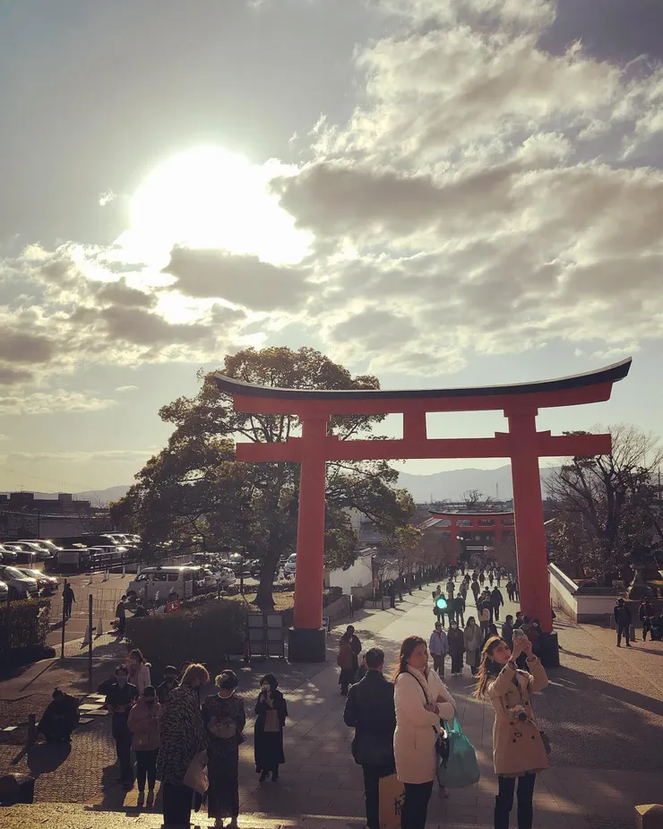 伏見稻荷大社的入口，是旅程的起點。高聳的鳥居映著冬陽，橘紅與光遼闊交織成莊嚴的門。