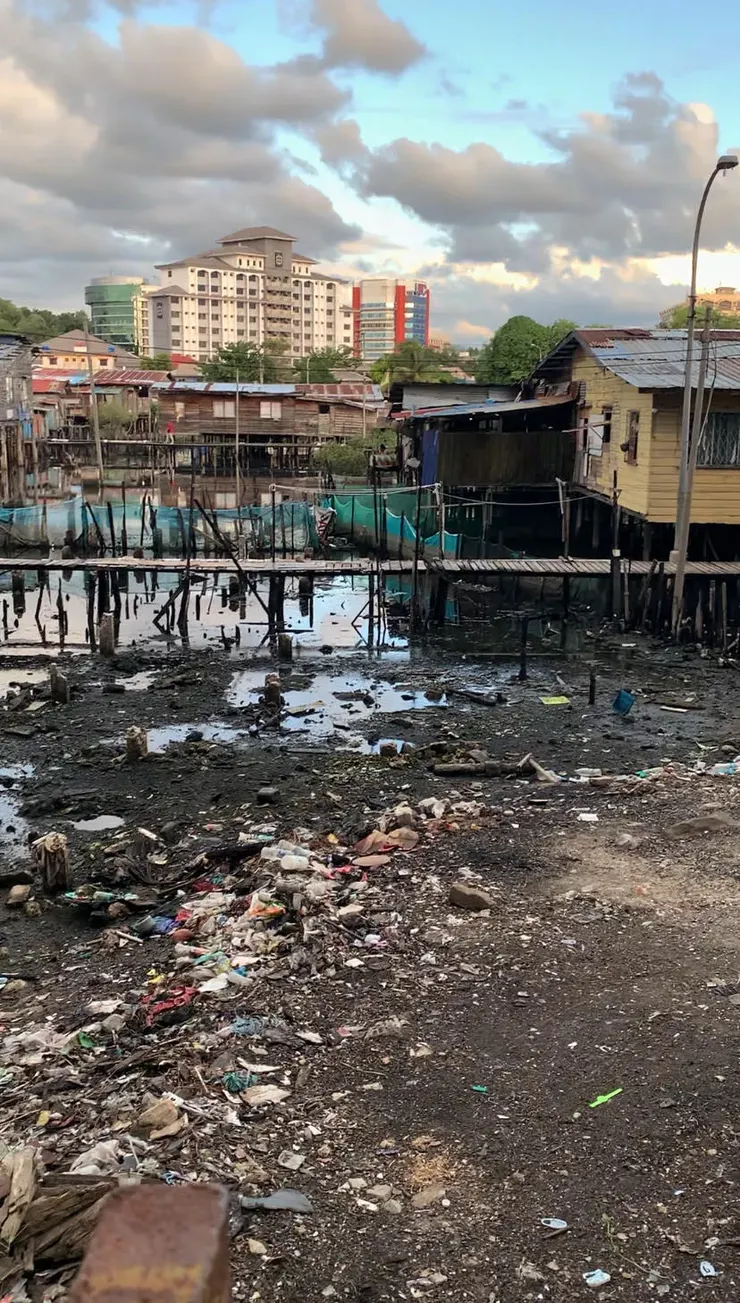 聚落一旁的出海口累積了滿坑的垃圾，孩子們就在這裡嬉戲玩耍。