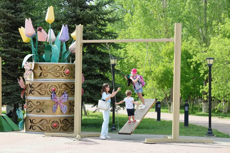 哈薩克媽媽幫孩子盪鞦韆。