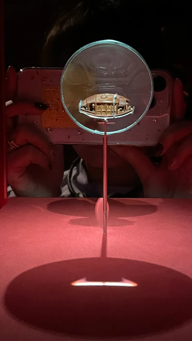 陳祖章的雕橄欖核舟，這個真的超超超迷你（照片背景的人手可以當作比例尺），重點是，這艘船都這麼小了，它的窗子還能開，而舟底刻了《後赤壁賦》全文（我都背不全了......）。清乾隆二年，故宮典藏。