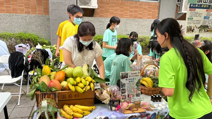 學市集，透過擺攤還有與民眾、老師、國中生的對答來增進口語說明能力
