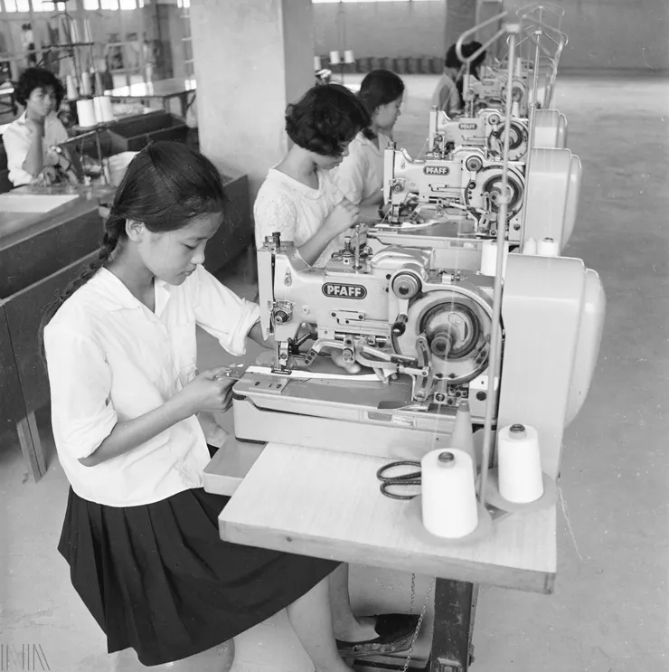 刊頭 年少的女性作業員在製衣廠裡縫紉成衣。 檔號：A325000000E/0055/0013/1