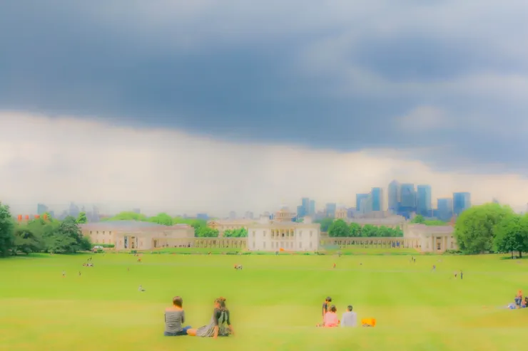 一路向下的綠色山坡草地上，坐著一點一點的人們