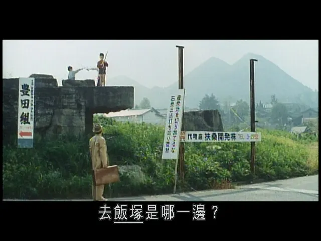 阿寅向路邊的小孩問路，背景是住友忠隈炭鑛的捨石山，美稱為「筑豐富士」