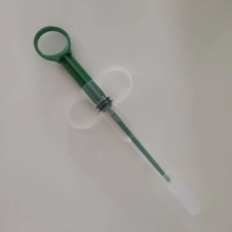 把膠囊夾在軟管上，綠色桿抵在膠囊尾端，肉泥擠膠囊上騙吃