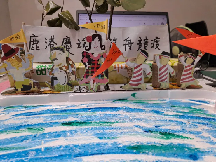 岸邊的啦啦隊則以穿著不同服飾，手拿不同顏色隊旗區分