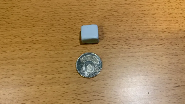 10 元硬幣上方的是 7 克重的 Blu Tack