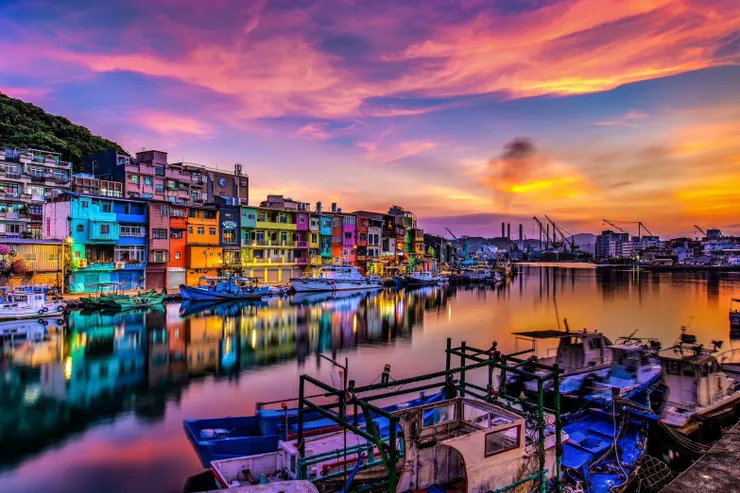 正濱漁港夕陽染上天空色彩，倒映在水面的彩色屋更添浪漫。圖/北海岸及觀音山國家風景區管理處提供