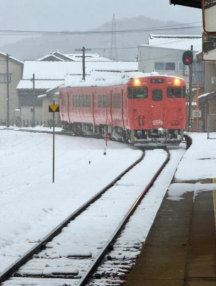 冰見橘紅色火車雪中緩緩駛入車站 作者拍攝
