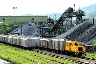 牽引水泥斗車往儲運站的調車機，後方是砂石場