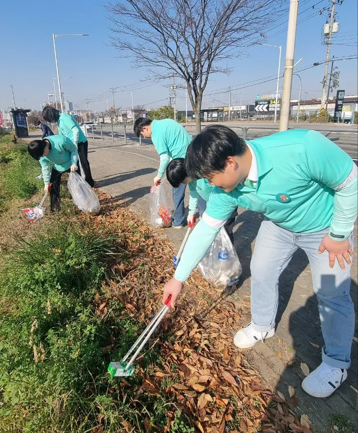 2025年11月16日，新天地金浦教會的學生們在十字路口的大道旁進行環境清潔活動。（新天地金浦教會提供）