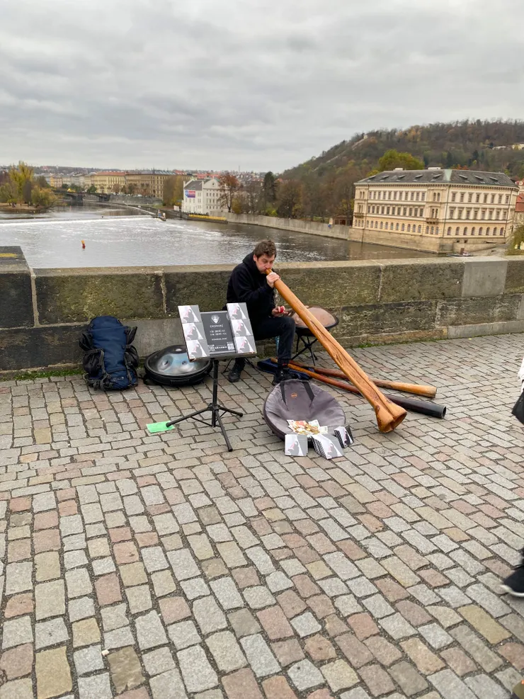▲橋上演奏樂器的街頭藝人，照片中他吹奏的是來自澳洲原住民的傳統樂器「迪吉里杜管」（Didgeridoo），樂音渾厚低沉；而在他左右兩側像飛碟的是「手碟」（Handpan），用手指敲擊能表現出清脆、空靈的聲音。