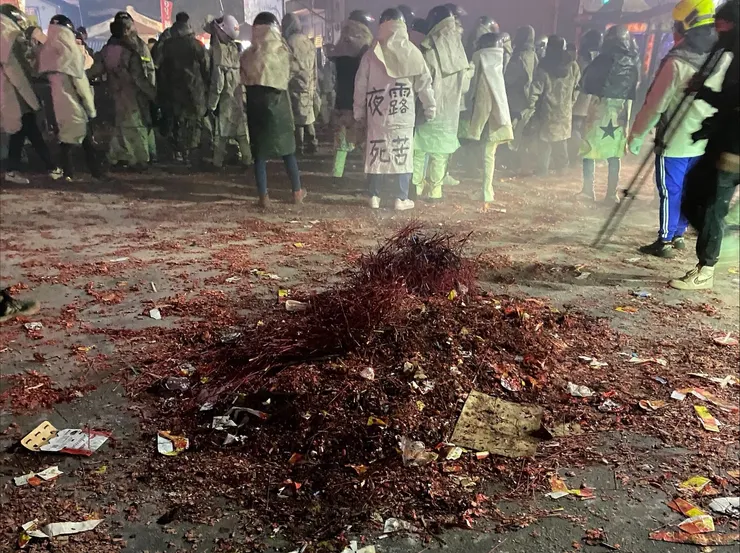 一座座小炮城激情狂炸後，地板留下厚如紅毯的「枝條」，得靠工作人員用大鏟子集中起來，才能把下個小炮城推過來開炸。（攝：抱城，2024/2/23。）