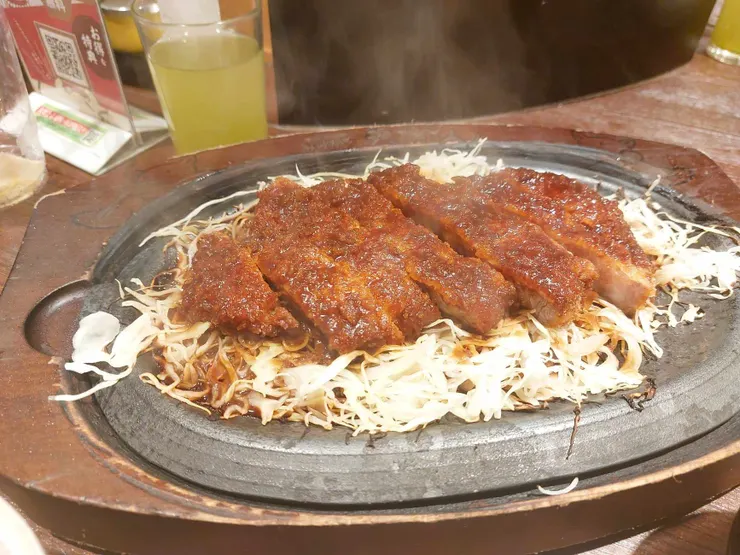 炸豬排在高溫的鐵板上冒出濃濃白煙，真的看起來十分美味