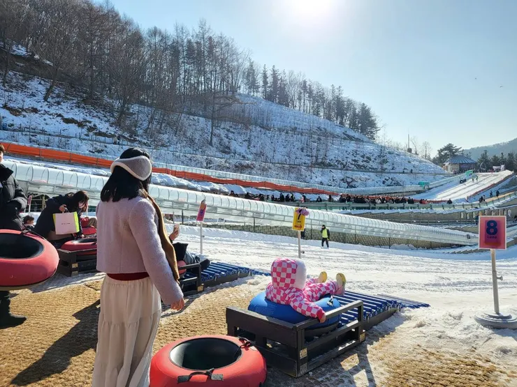 在兒童雪橇場拿好雪盆排隊
