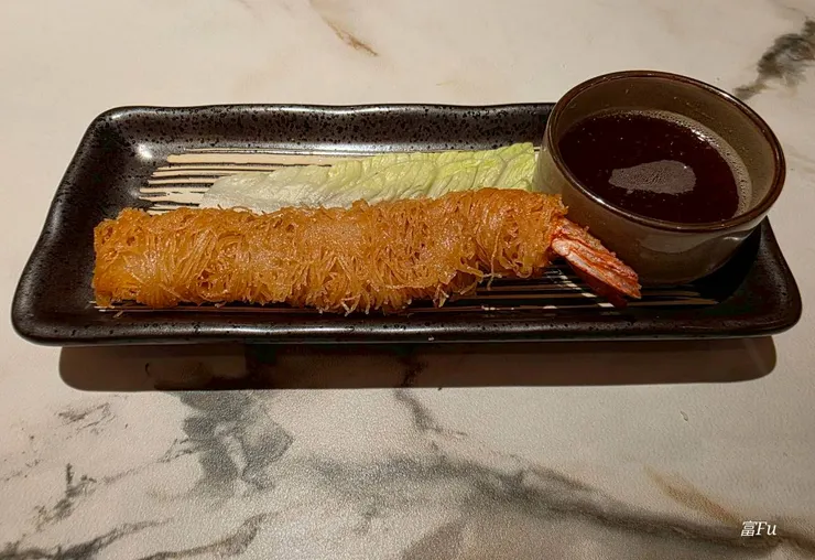 外層裹成一絲一絲的，像是炸麵線一樣，內餡為鮮甜海老(蝦子)。