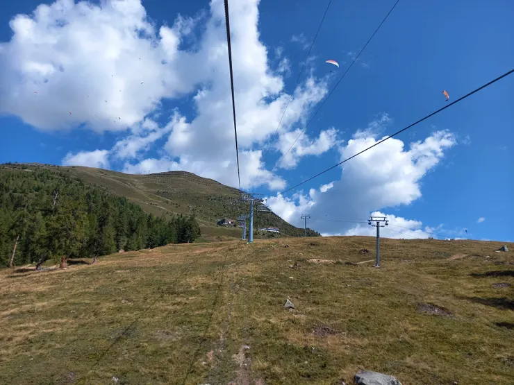 乘Bellwald纜車上山，已經可以看到飛行傘玩家了(左上白雲上有幾個黑點，不是你螢幕髒髒的，那些都是飛行傘!)