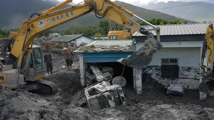 怪手將障礙物移除後，旁邊待命的志工就會下去幫忙