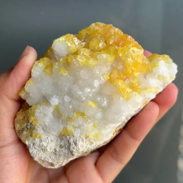 這顆標本中自然硫覆蓋在塊狀的天青石上，可看到濃郁黃而透的自然硫晶體，與玻璃光澤的天青石晶體形成對比。