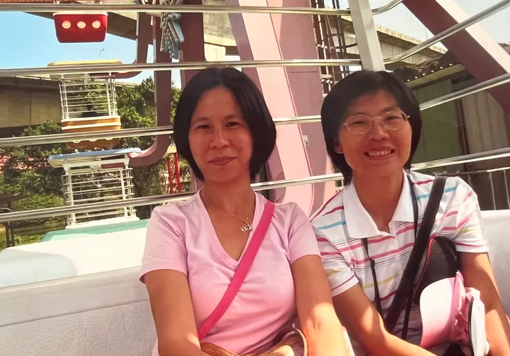 我們去坐摩天輪，其中一位小朋友幫媽媽照相。我們身上背的應該都是小朋友的皮包，尤其我身上那個顏色未免太鮮豔了