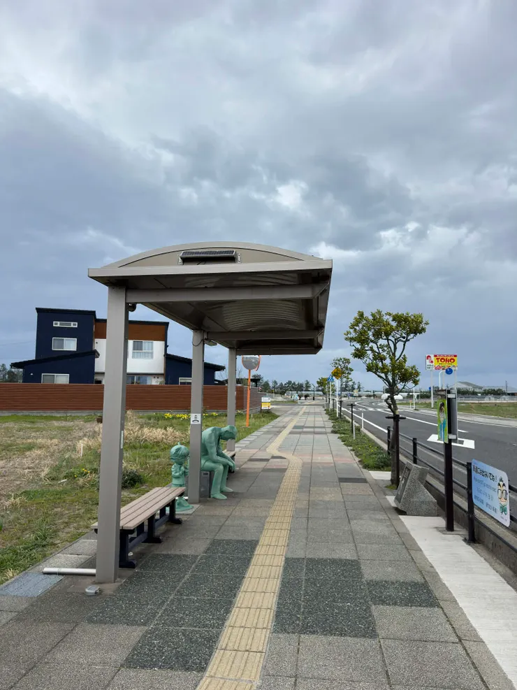 沿著路走會看到公車站牌，底下坐的是...!?