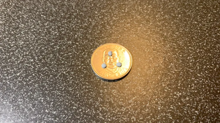 黏上 3 小點 Blu Tack 的 10 元硬幣