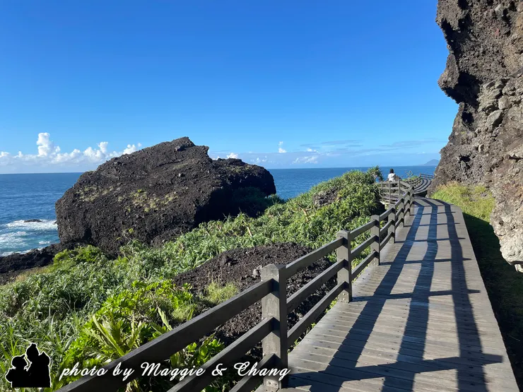走在回程的海岸小徑上，耳邊是海浪聲，眼前是藍天與大海，欄杆的影子在陽光下交織成獨特的節奏，讓人不禁放慢腳步，細細感受這片寧靜。